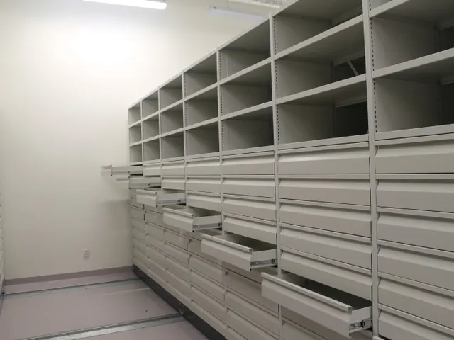 Light-coloured archive shelving with drawers